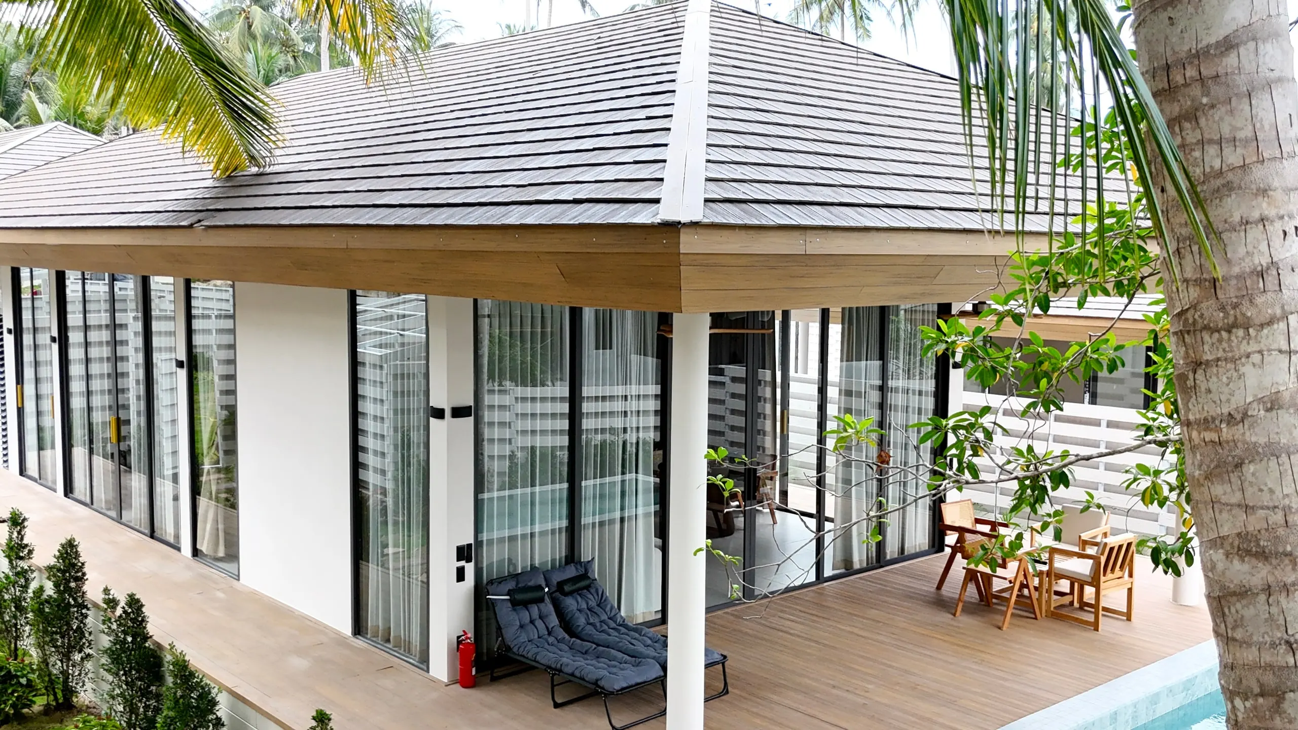 White Lotus Villa II — turquoise pool and terrace under the timber-slat roof soffit